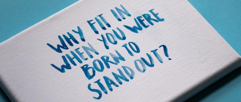 Canvas with motivational quote 'Why fit in when you were born to stand out?' on blue background.